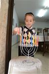 A child lights a menorah at the entrance facing the public domain