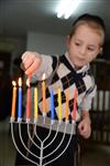 A child lights a menorah at the entrance facing the public domain