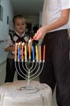 A child lights a menorah at the entrance facing the public domain