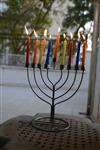 A child lights a menorah at the entrance facing the public domain