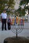 A child lights a menorah at the entrance facing the public domain