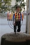 A child lights a menorah at the entrance facing the public domain