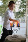 A child lights a menorah at the entrance facing the public domain