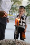 A child lights a menorah at the entrance facing the public domain