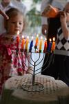 A child lights a menorah at the entrance facing the public domain