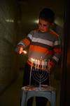 A child lights a menorah at the entrance facing the public domain