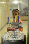 A child lights a menorah at the entrance facing the public domain