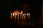 A child lights a menorah at the entrance facing the public domain