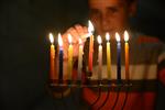 A child lights a menorah at the entrance facing the public domain