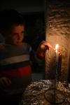 A child lights a menorah at the entrance facing the public domain