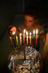 A child lights a menorah at the entrance facing the public domain