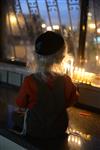 A child lights a menorah at the entrance facing the public domain