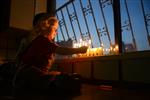 A child lights a menorah at the entrance facing the public domain