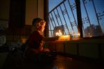 A child lights a menorah at the entrance facing the public domain