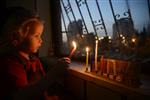 A child lights a menorah at the entrance facing the public domain