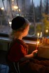 A child lights a menorah at the entrance facing the public domain