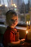 A child lights a menorah at the entrance facing the public domain