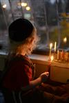 A child lights a menorah at the entrance facing the public domain