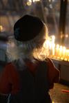 A child lights a menorah at the entrance facing the public domain