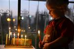 A child lights a menorah at the entrance facing the public domain