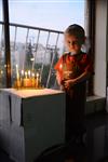 A child lights a menorah at the entrance facing the public domain