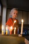 A child lights a menorah at the entrance facing the public domain