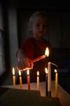 A child lights a menorah at the entrance facing the public domain