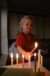 A child lights a menorah at the entrance facing the public domain