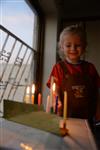 A child lights a menorah at the entrance facing the public domain