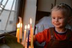 A child lights a menorah at the entrance facing the public domain