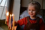 A child lights a menorah at the entrance facing the public domain