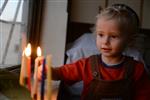 A child lights a menorah at the entrance facing the public domain