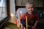 A child lights a menorah at the entrance facing the public domain