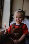 A child lights a menorah at the entrance facing the public domain