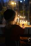 A child lights a menorah at the entrance facing the public domain