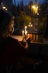 A child lights a menorah at the entrance facing the public domain