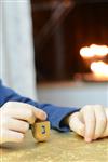 Child playing dreidel during the Hanukkah holiday by the menorah lit