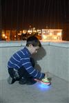 Child playing dreidel during the Hanukkah holiday by the menorah lit