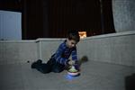 Child playing dreidel during the Hanukkah holiday by the menorah lit