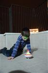 Child playing dreidel during the Hanukkah holiday by the menorah lit