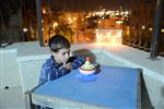 Child playing dreidel during the Hanukkah holiday by the menorah lit