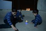 Child playing dreidel during the Hanukkah holiday by the menorah lit