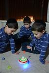 Child playing dreidel during the Hanukkah holiday by the menorah lit