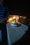 Child playing dreidel during the Hanukkah holiday by the menorah lit