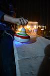 Child playing dreidel during the Hanukkah holiday by the menorah lit