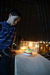 Child playing dreidel during the Hanukkah holiday by the menorah lit