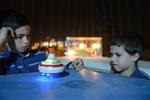 Child playing dreidel during the Hanukkah holiday by the menorah lit