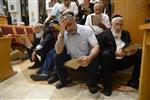 יהודים עורכים תפילת תיקון חצות על הרצפה בבית כנסת