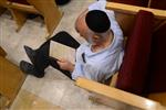 יהודים עורכים תפילת תיקון חצות על הרצפה בבית כנסת