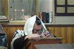 Jews praying in the synagogue with prayer shawl and phylacteries